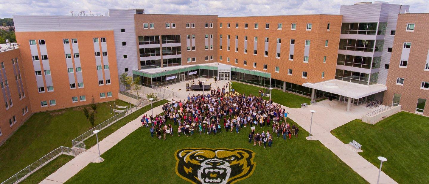 航拍照片，一大群华大学生站在北大校园，地面上画着巨大的棕熊吉祥物